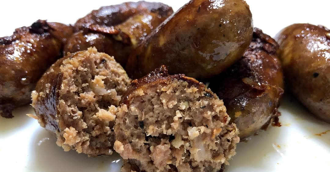 Cooked Ilocos longganisa close-up showing garlic-rich filling